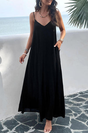 a woman in a black dress standing by the ocean
