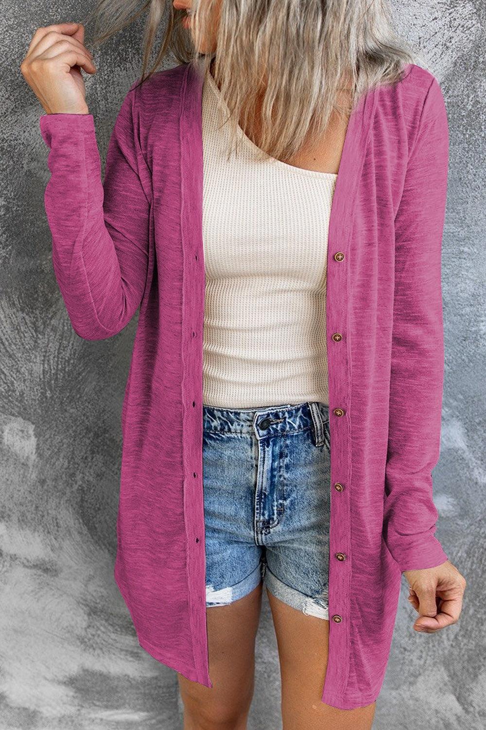 a woman wearing a pink cardigan and denim shorts