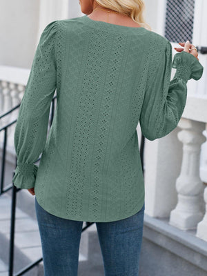 a woman wearing a green sweater and jeans