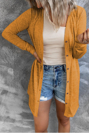 a woman with blonde hair wearing a yellow cardigan