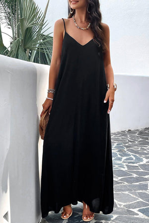 a woman in a black dress leaning against a wall