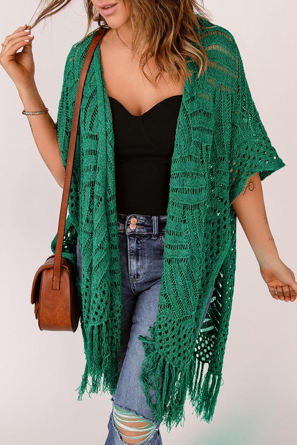 a woman wearing a green shawl and jeans