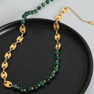 a green beaded necklace on a black plate