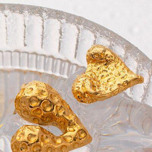 two gold hearts on a clear glass plate