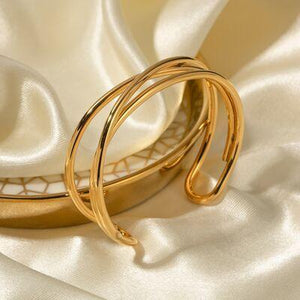 a pair of gold rings sitting on top of a white cloth