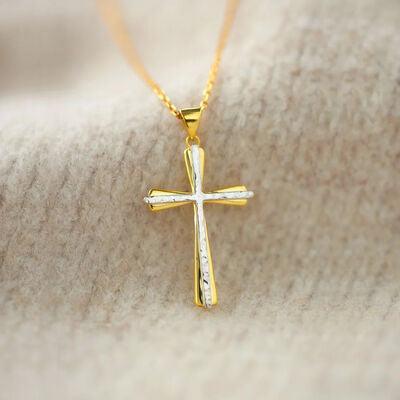 a gold cross necklace on a white background