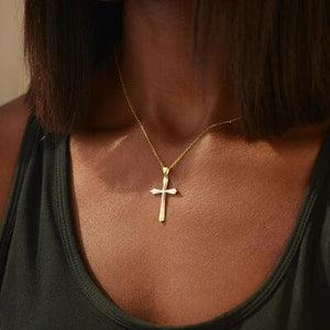 a woman wearing a necklace with a cross on it