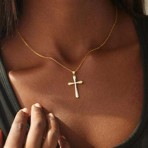 a woman wearing a necklace with a cross on it