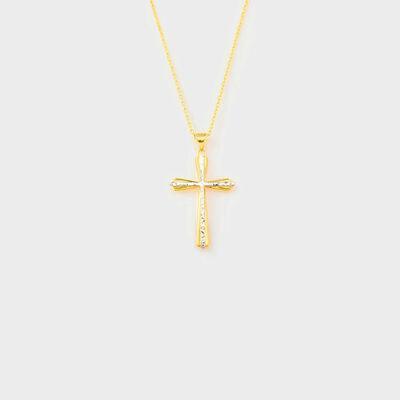 a gold cross necklace on a white background