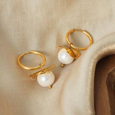 a pair of gold hoop earrings with white pearls