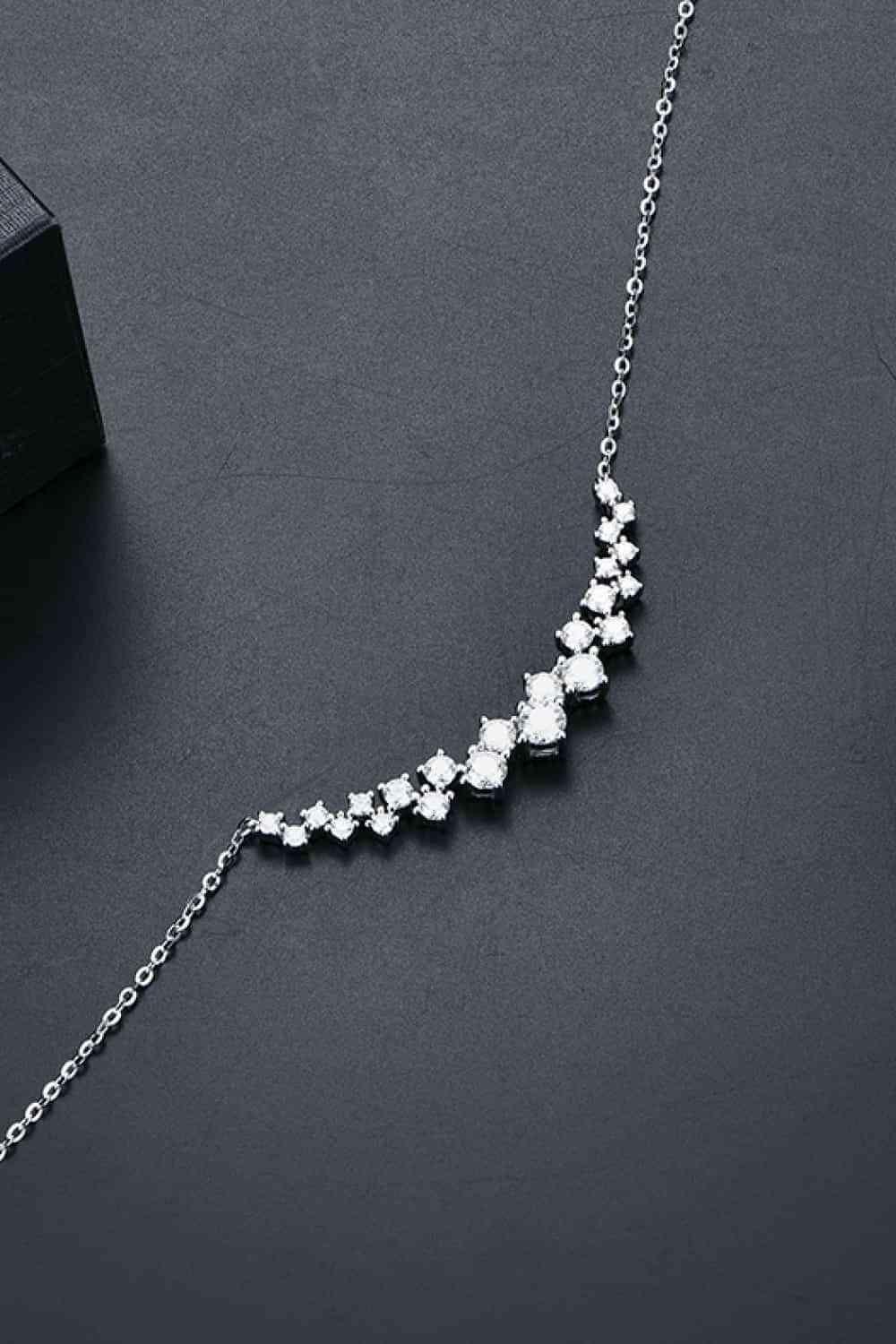 a necklace with five diamonds on a black surface