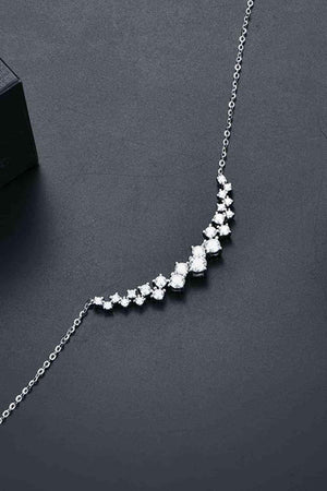 a necklace with five diamonds on a black surface