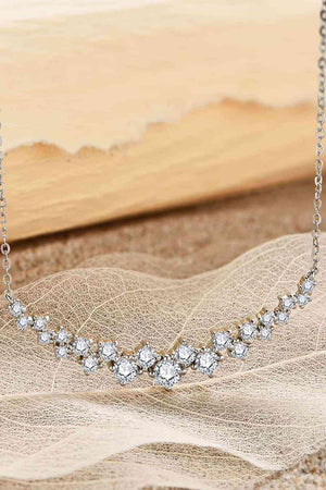 a diamond necklace sitting on top of a leaf