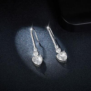 a pair of diamond earrings on a black surface