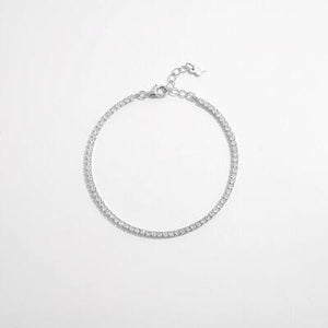 a silver bracelet with white beads on a white background