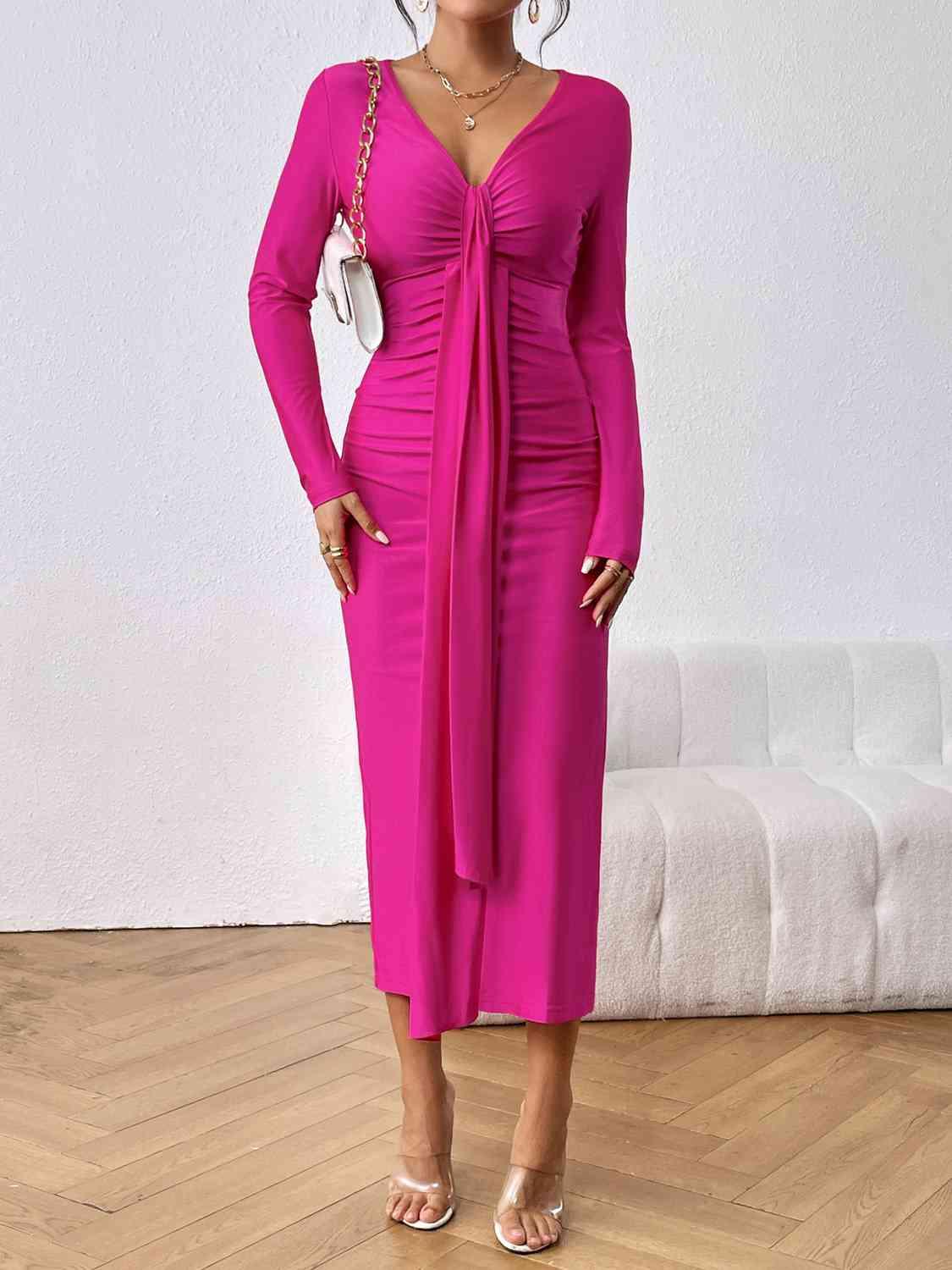 a woman in a pink dress standing on a wooden floor