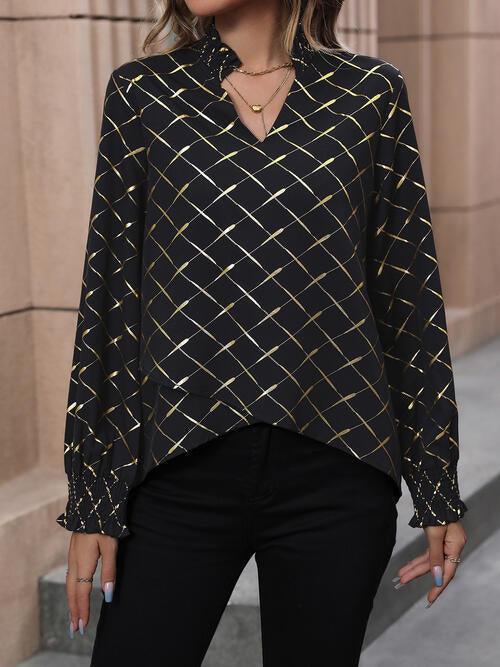 a woman wearing a black and gold blouse