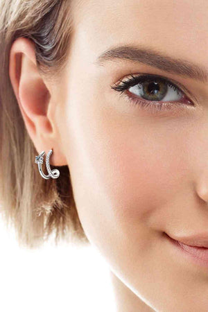 a close up of a person wearing a pair of earrings