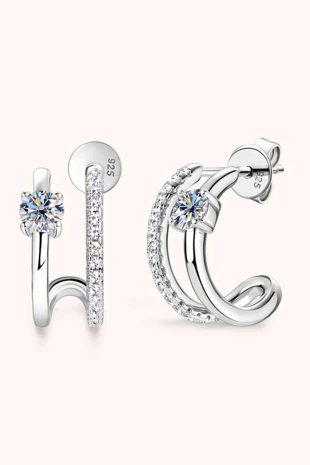 a pair of earrings with a diamond in the middle