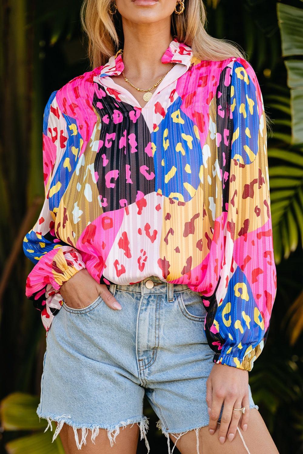 a woman wearing a colorful shirt and denim shorts