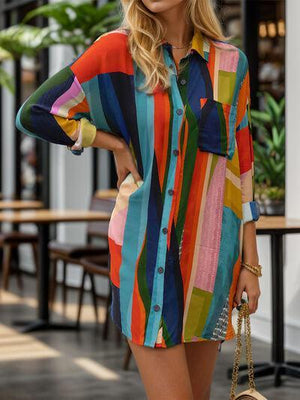 a woman in a colorful shirt dress holding a handbag