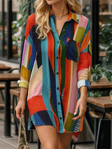 a woman in a colorful shirt dress walking down the street