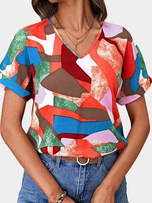 a woman wearing a colorful shirt and jeans