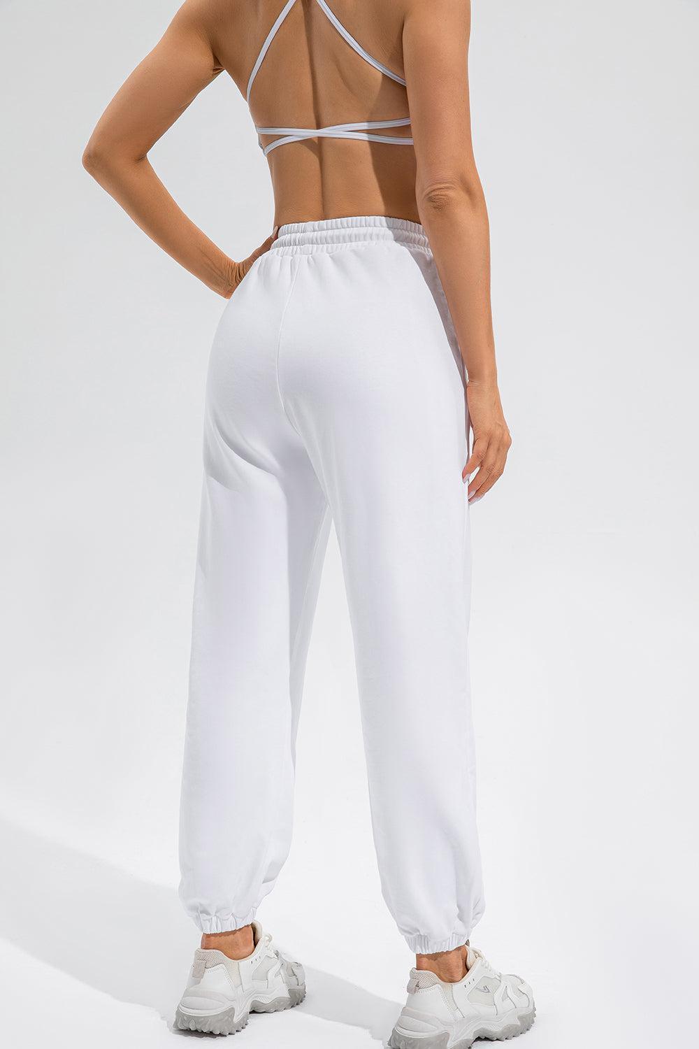 a woman in white pants and a bra top