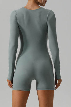 a woman in a grey bodysuit with her back to the camera