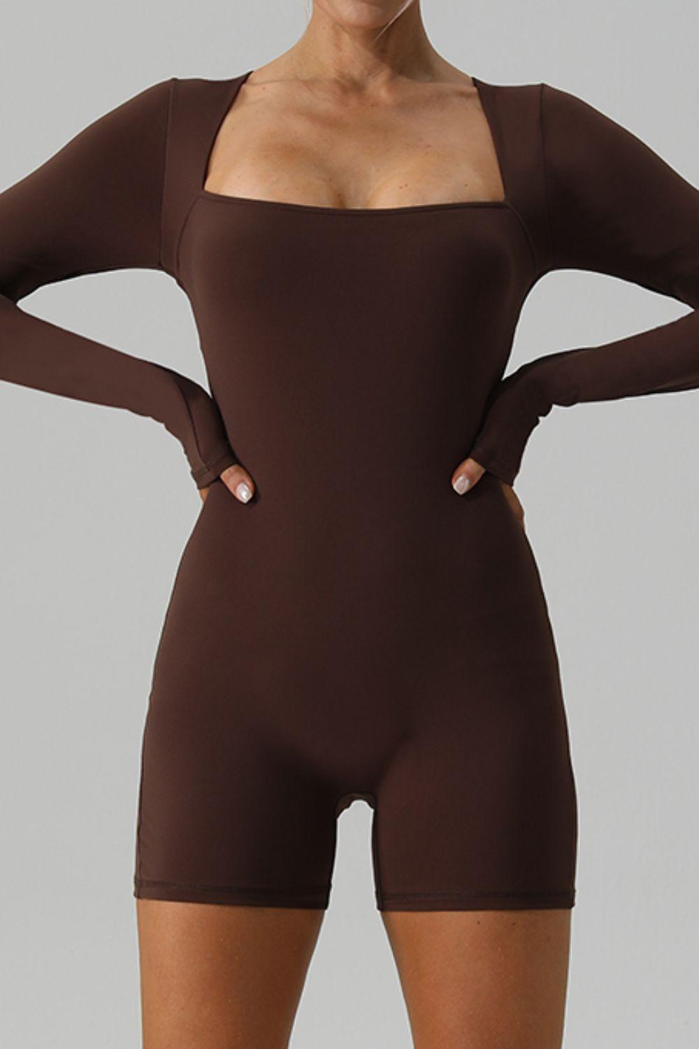 a woman in a brown bodysuit posing for the camera