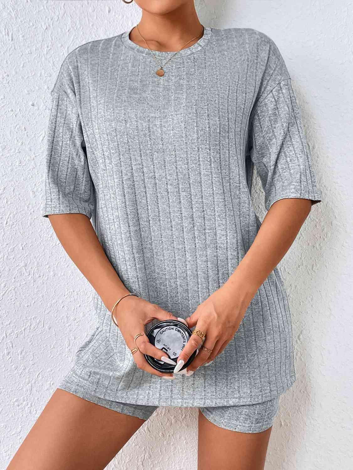 a woman wearing a gray sweater and shorts