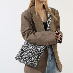 a woman is holding a leopard print purse