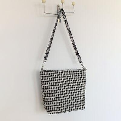 a black and white purse hanging on a wall