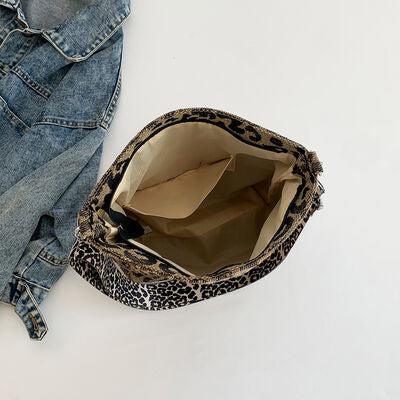 a purse sitting on top of a pair of jeans
