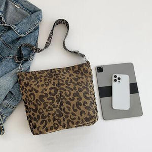 a cell phone and a purse on a white surface