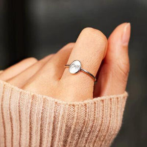 a person wearing a ring with a heart on it