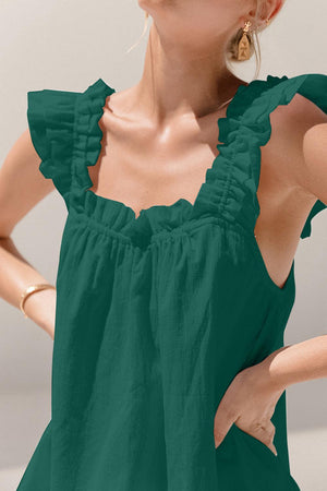 a woman wearing a green top with ruffles on it