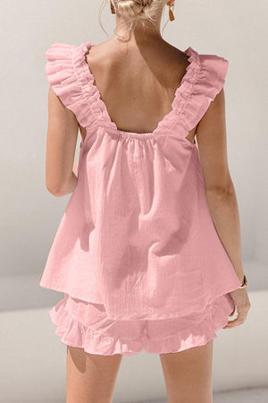 the back of a woman's pink dress with ruffles