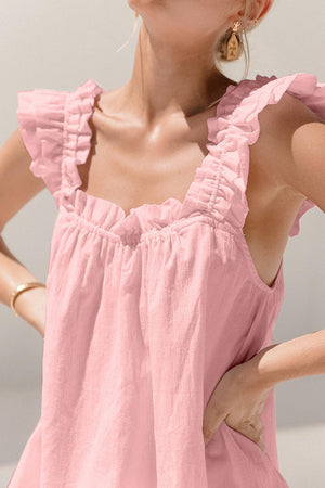 a woman wearing a pink dress with ruffles on it