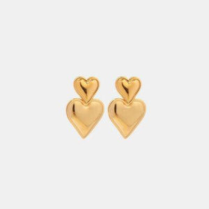 a pair of gold heart earrings on a white background