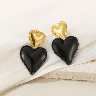 a pair of black and gold heart shaped earrings