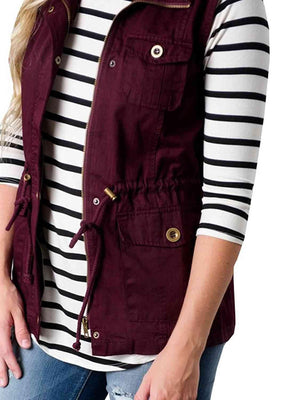 a woman wearing a striped shirt and a maroon vest