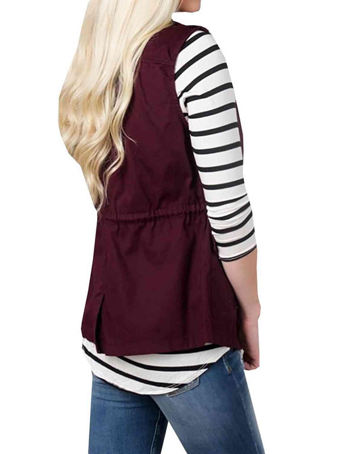 a woman with long blonde hair wearing a maroon vest