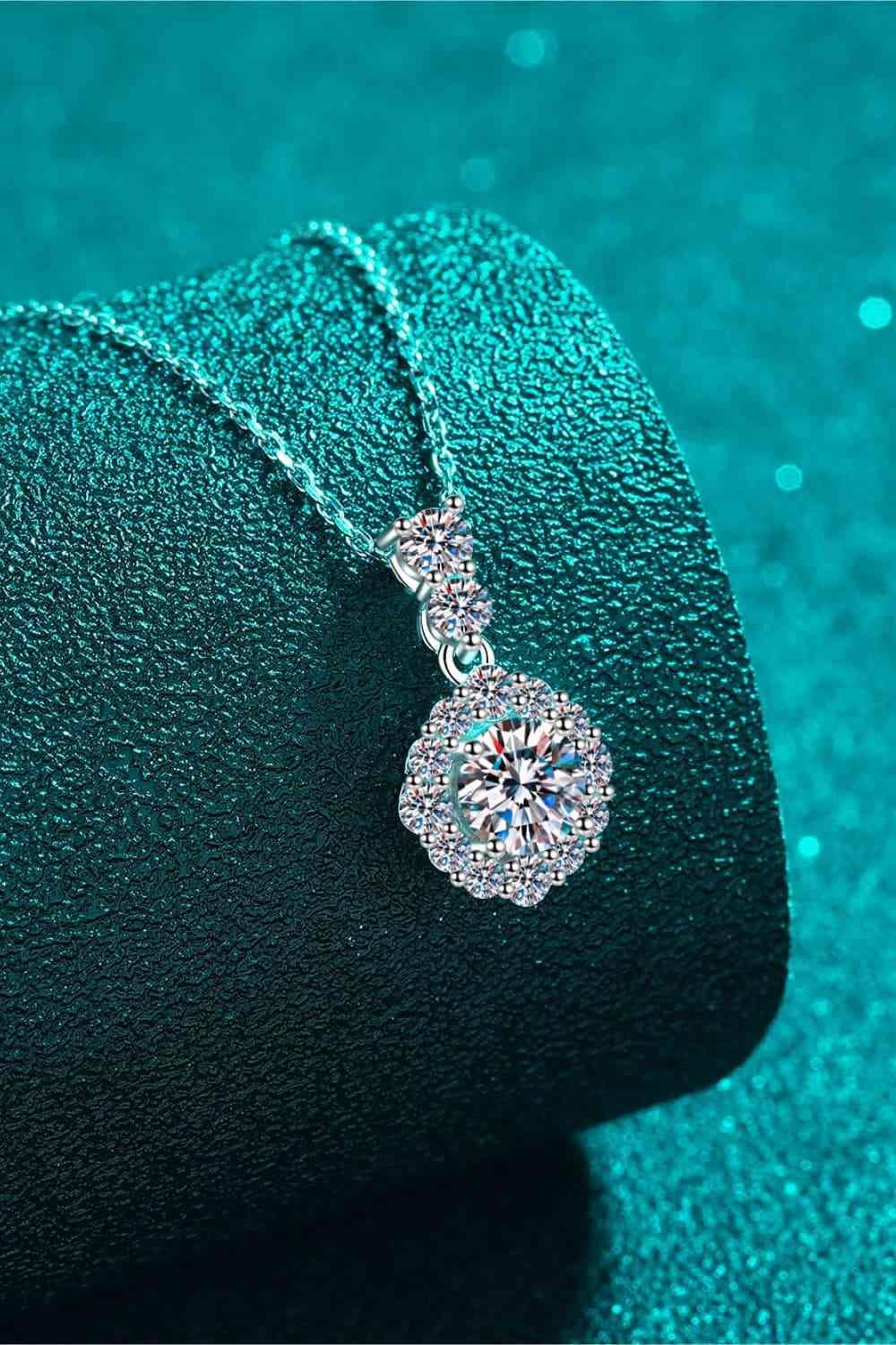 a close up of a diamond necklace on a green surface