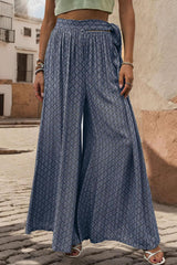 a woman standing on a cobblestone street wearing a green crop top and blue