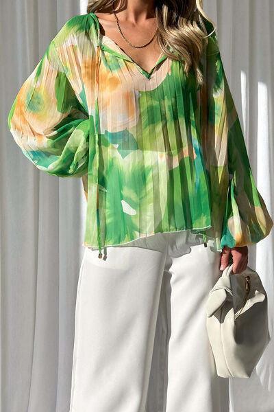 a woman wearing a green blouse and white pants