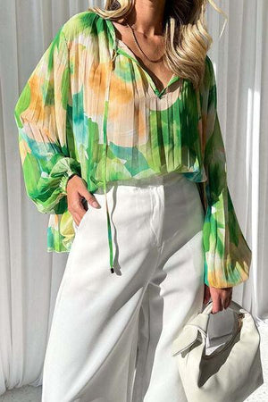 a woman wearing a green blouse and white pants