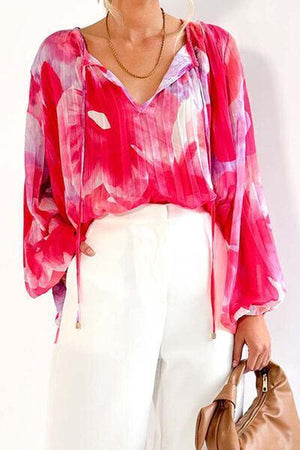 a woman in a pink blouse and white pants