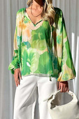 a woman wearing a green blouse and white pants