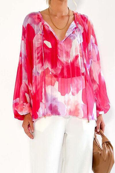 a woman wearing a pink blouse and white pants